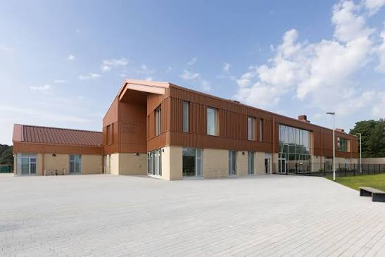 A contemporary public building and open paved space in Winchburgh